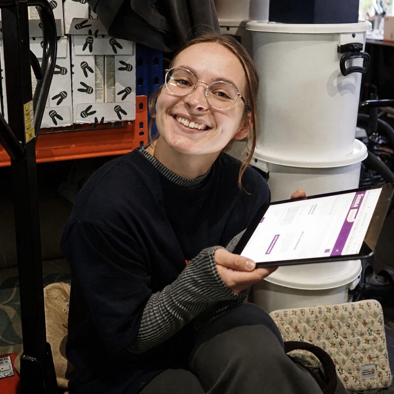 Smiling team member holding a tablet in the stockroom